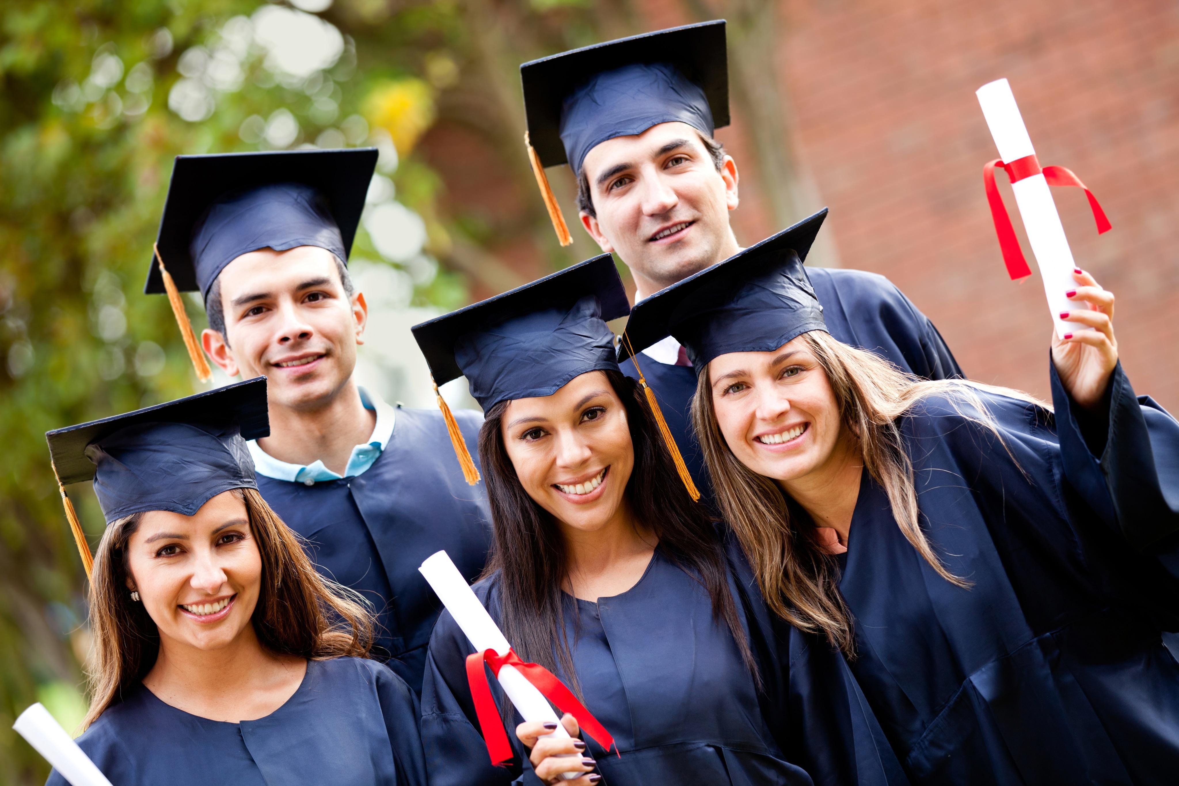 Group of graduate students holding their diploma after graduation Group of graduate students holding their diploma after graduation